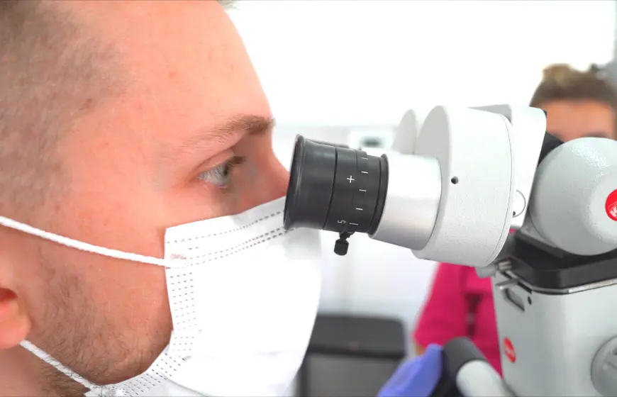 Lekarz dentysta przeprowadza dokładny przegląd stomatologiczny pod mikroskopem w PrecisDENT Centrum Implantologii i Stomatologii Mikroskopowej