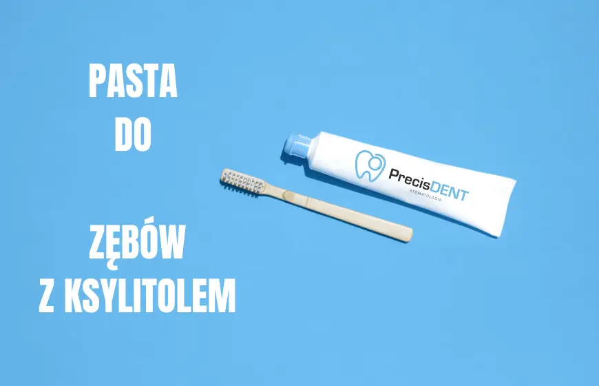 biała tubka pasty do zębów z błękitną nakrętką i logiem PrecisDENT Stomatologia oraz szczoteczka do zębów w kolorze beżowym. Obok napis "pasta do zćbów z ksylitolem"
